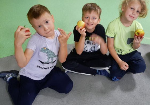 Chłopcy pokazują jabłka, które otrzymali od pani Kasi